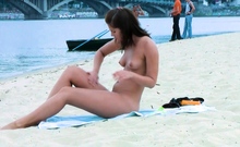 Playful young nudist with nice body is having fun the beach